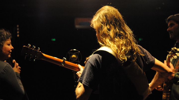 Le guitariste de dos, entre la contrebassiste et le banjoïste.