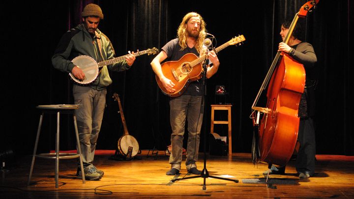 Le trio sur scène autour du micro unique.